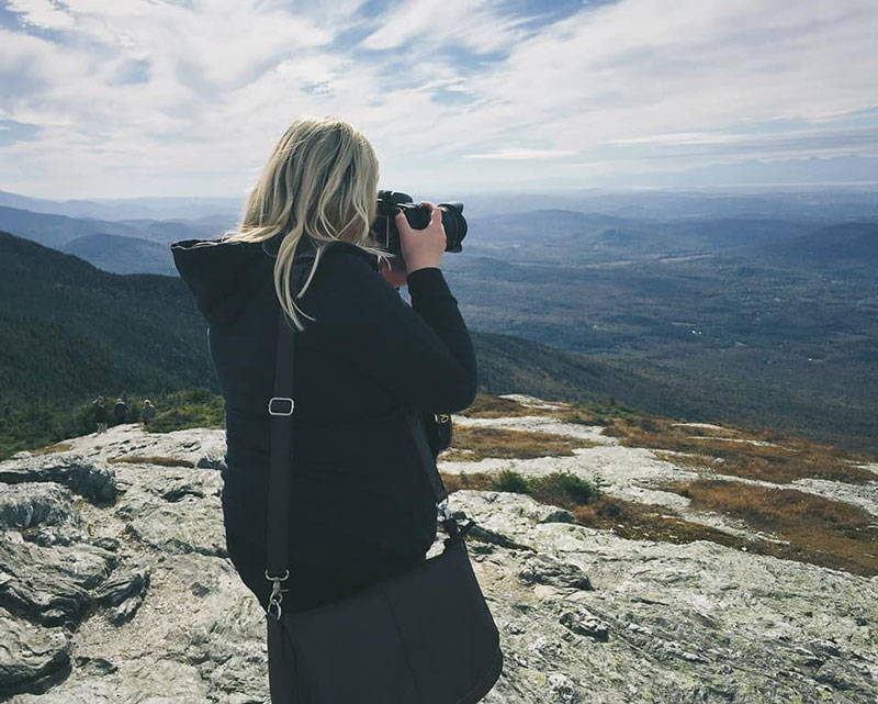 Girl taking pictures of mountains
