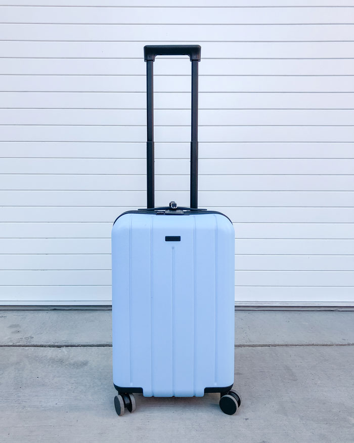 Blue carry on luggage against white background