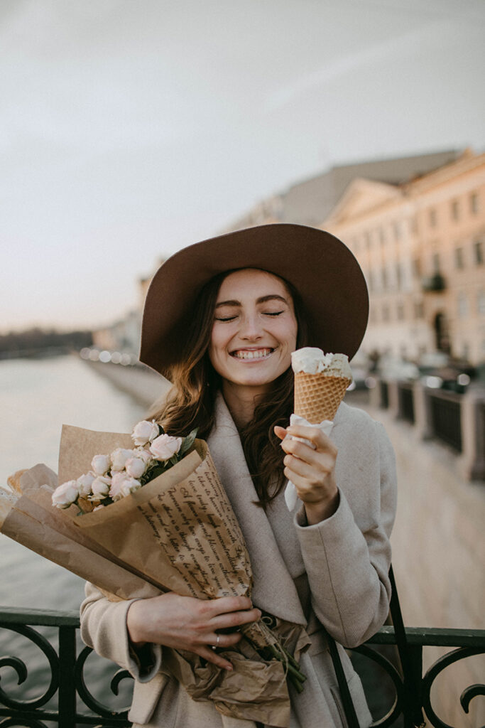 woman eating ice cream and holding a bouquet of roses 