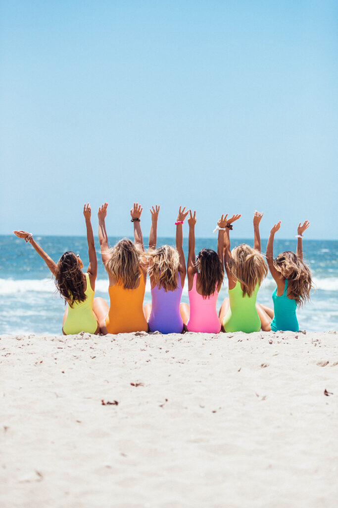 a group of women sitting on the beach