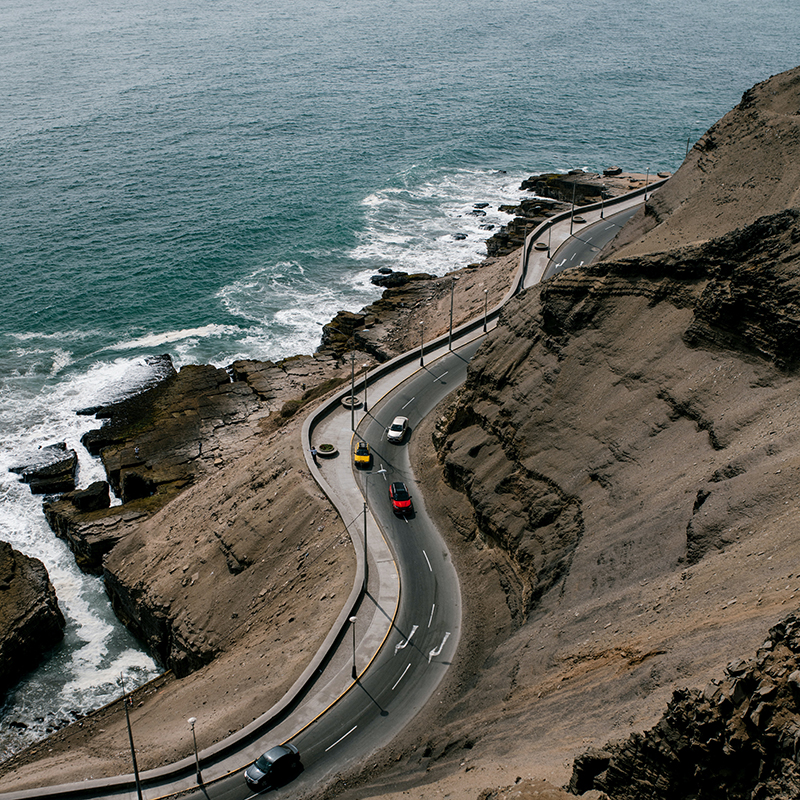 Cars driving along the coast of the ocean