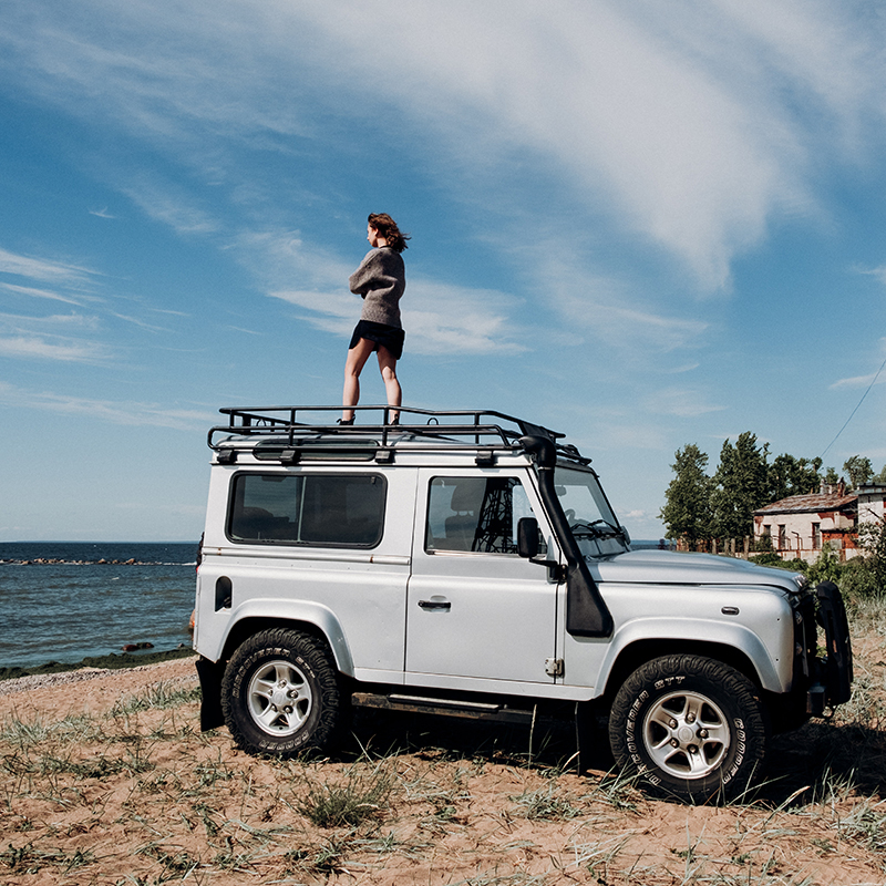 Woman standing on a large vehicle looking out at the ocean